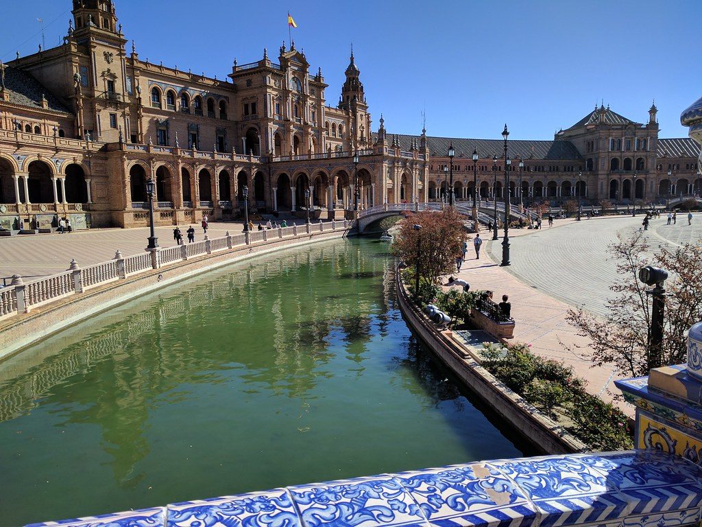 The curved brick colonnade and canal of the Plaza de Espana in Seville, Spain.