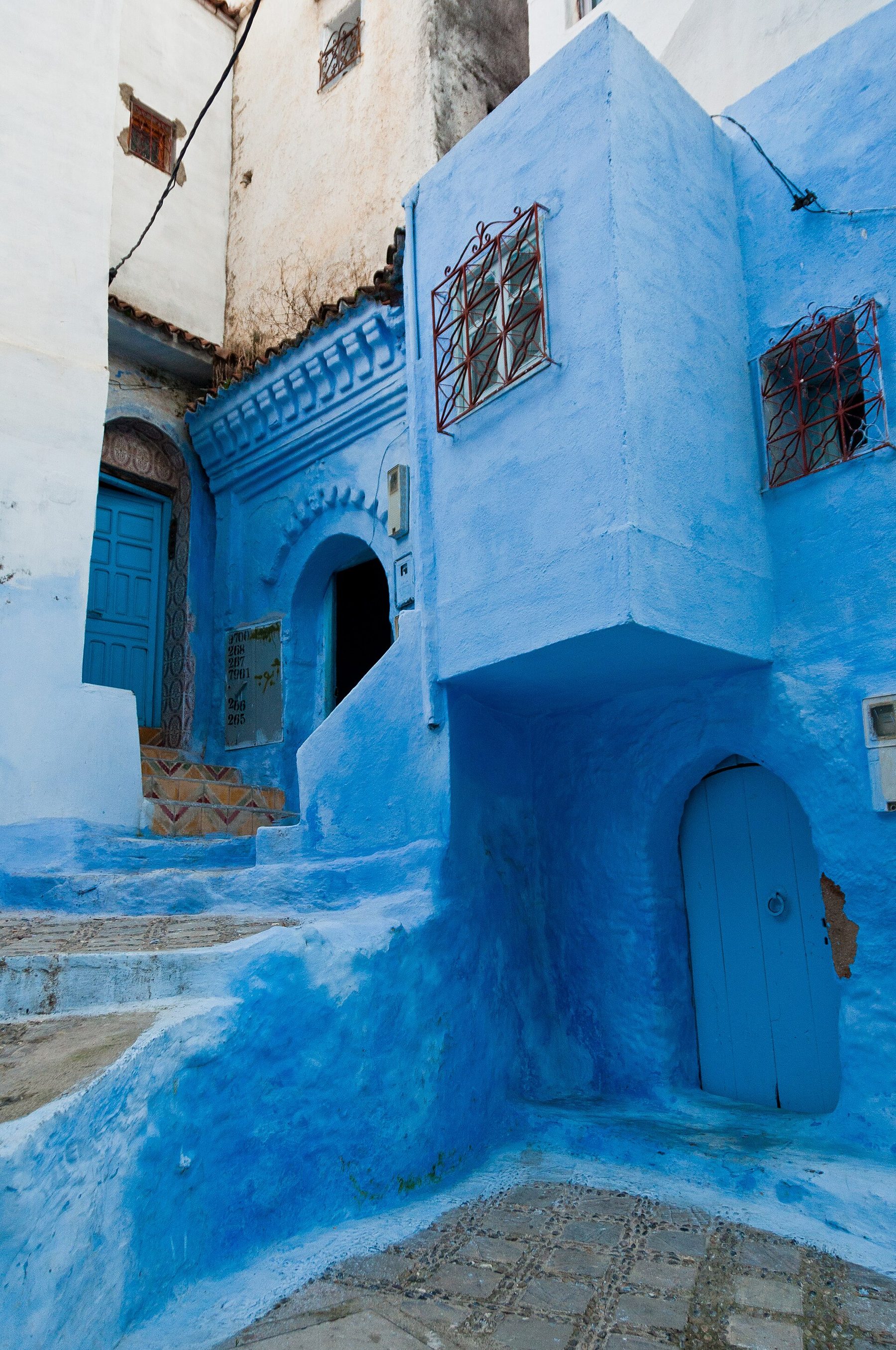A blue-painted archway and steps in the medina of Chefchaouen, Morocco.