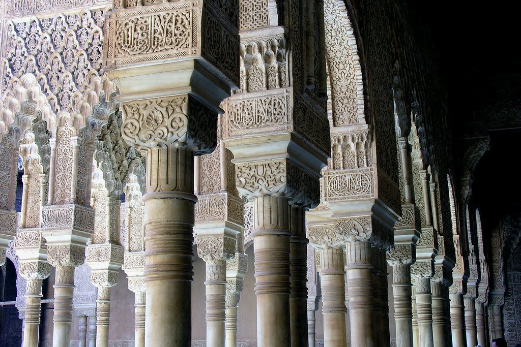 Carved plaster arches and slender columns in the Alhambra palace in Granada.